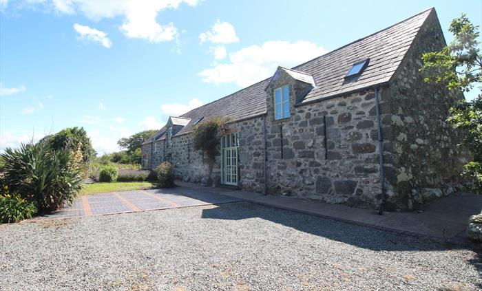 Photo of Ysgubor Degwm, a converted medieval barn on the Llyn Peninsula near Chwilog. Build from large irresgular stone this long barnhas a slate roof